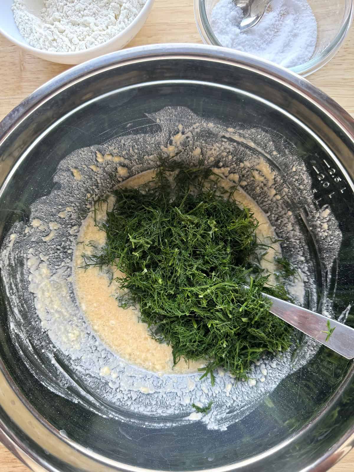 Chopped wild fennel stirred into fritters batter in large bowl.