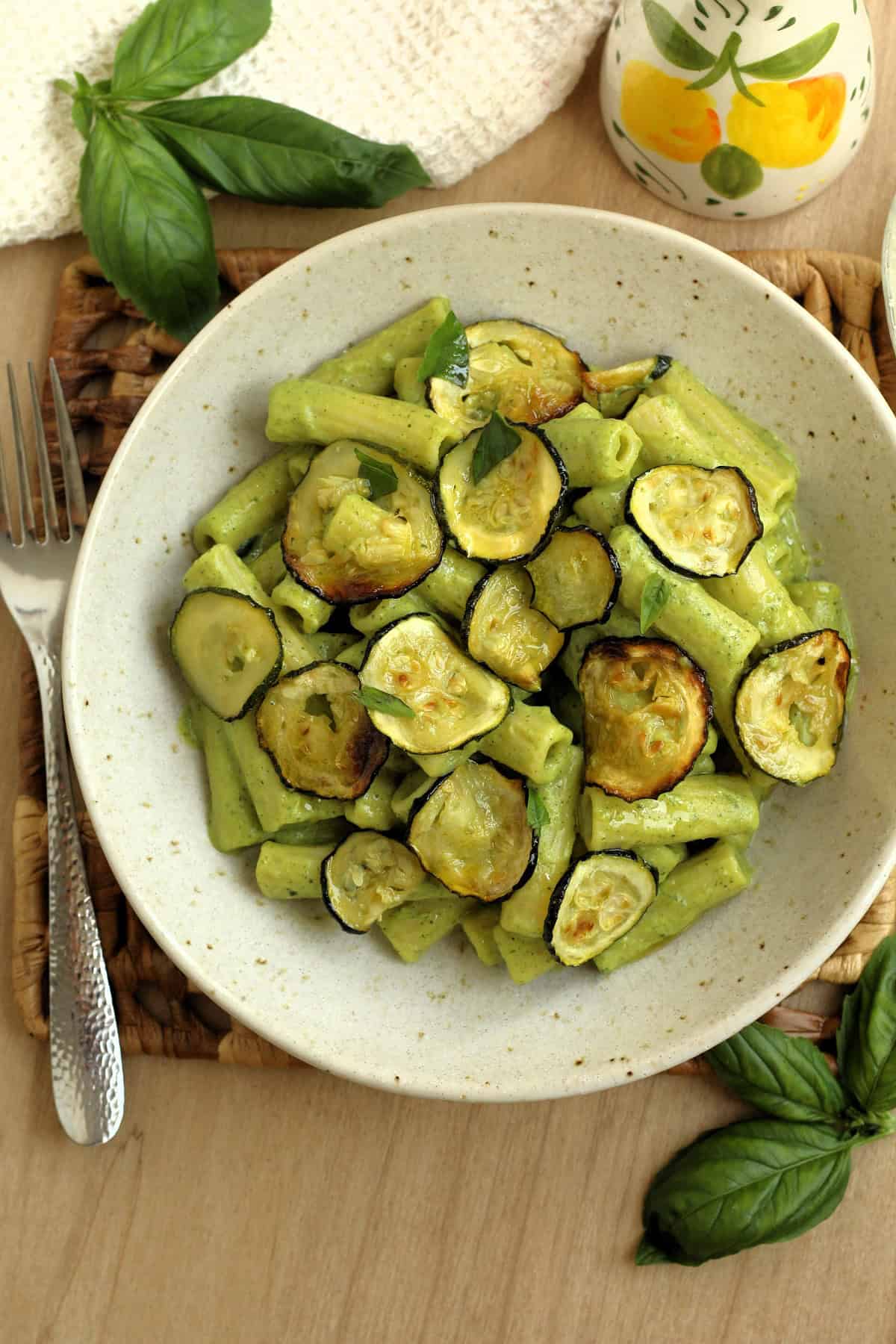 Bowl of pasta with zucchini pesto and roasted zucchini topped with fresh basil.