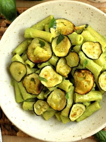 Bowl filled with pasta with zucchini 2 ways, zucchini pesto and oven roasted zucchini.