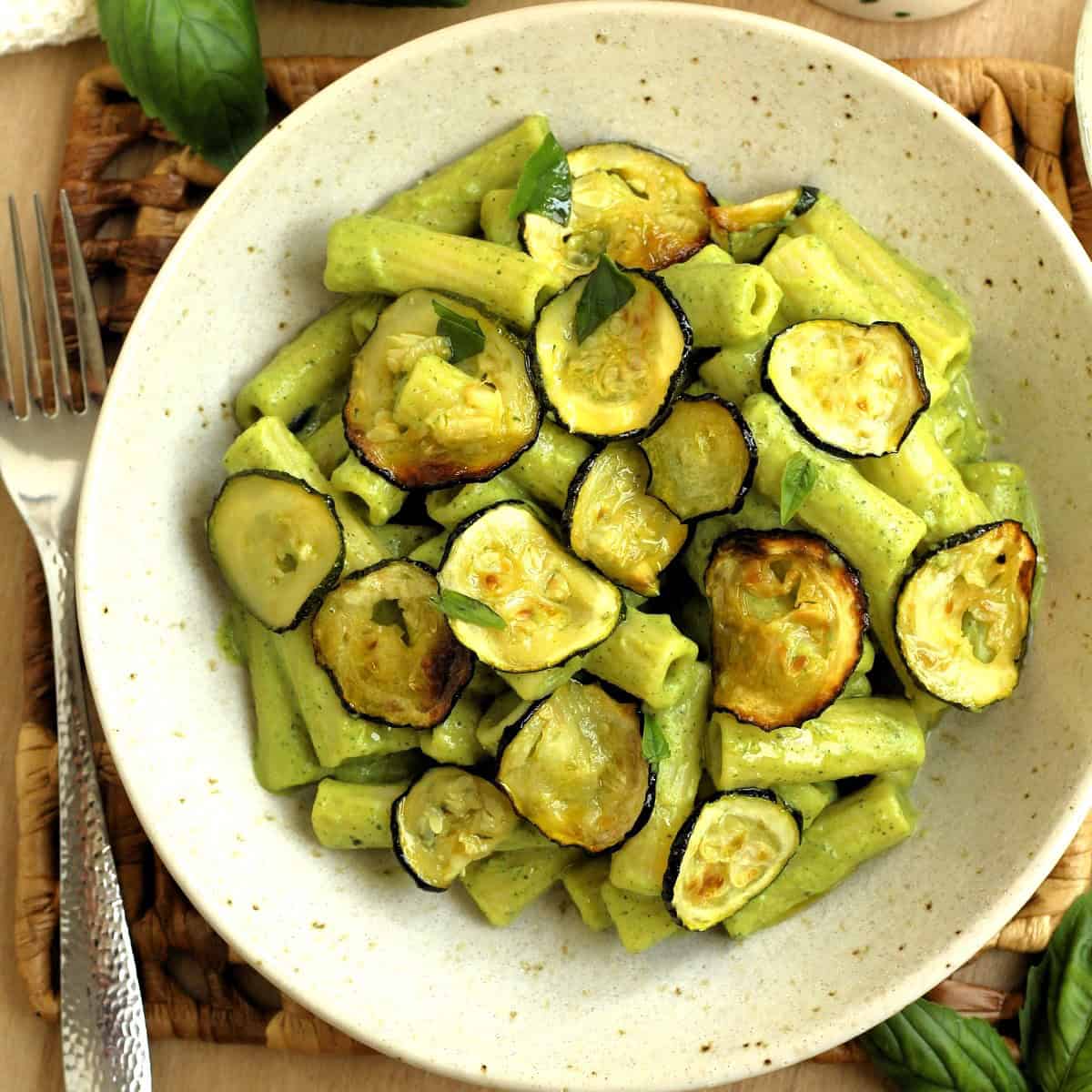 Bowl filled with pasta with zucchini 2 ways, zucchini pesto and oven roasted zucchini.