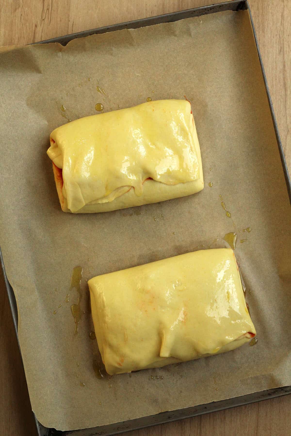 Scaccia dough brushed with olive oil on baking sheet.