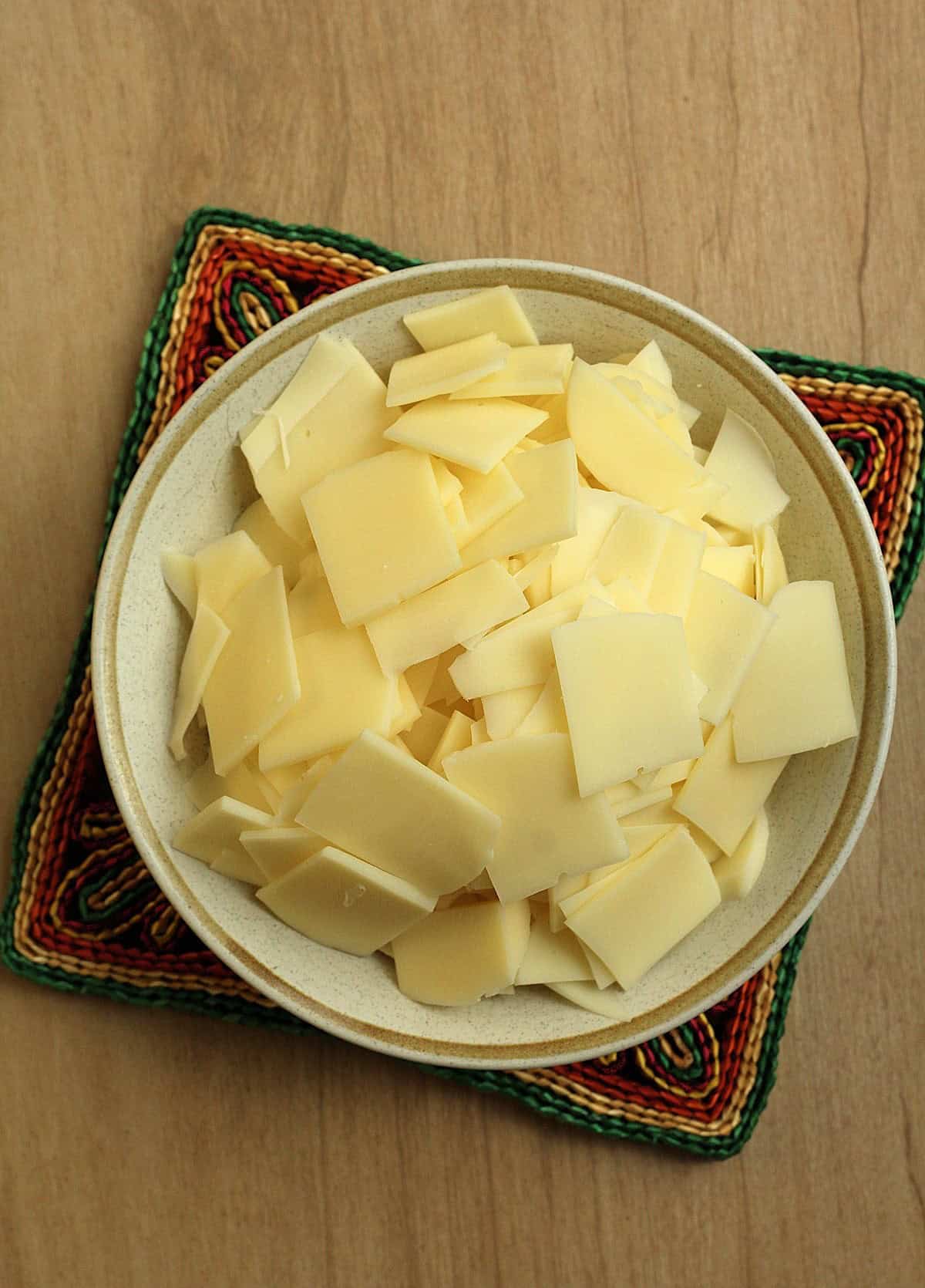 Thinly sliced caciocavallo cheese in bowl for scaccia filling.