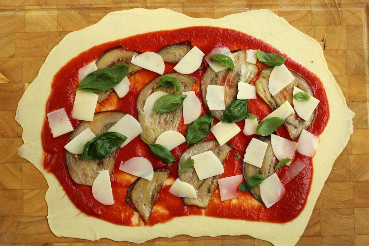 Scaccia Ragusana dough topped with eggplant slices.