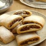Fig jam cookies (settembrini) dusted with powdered sugar on plate.