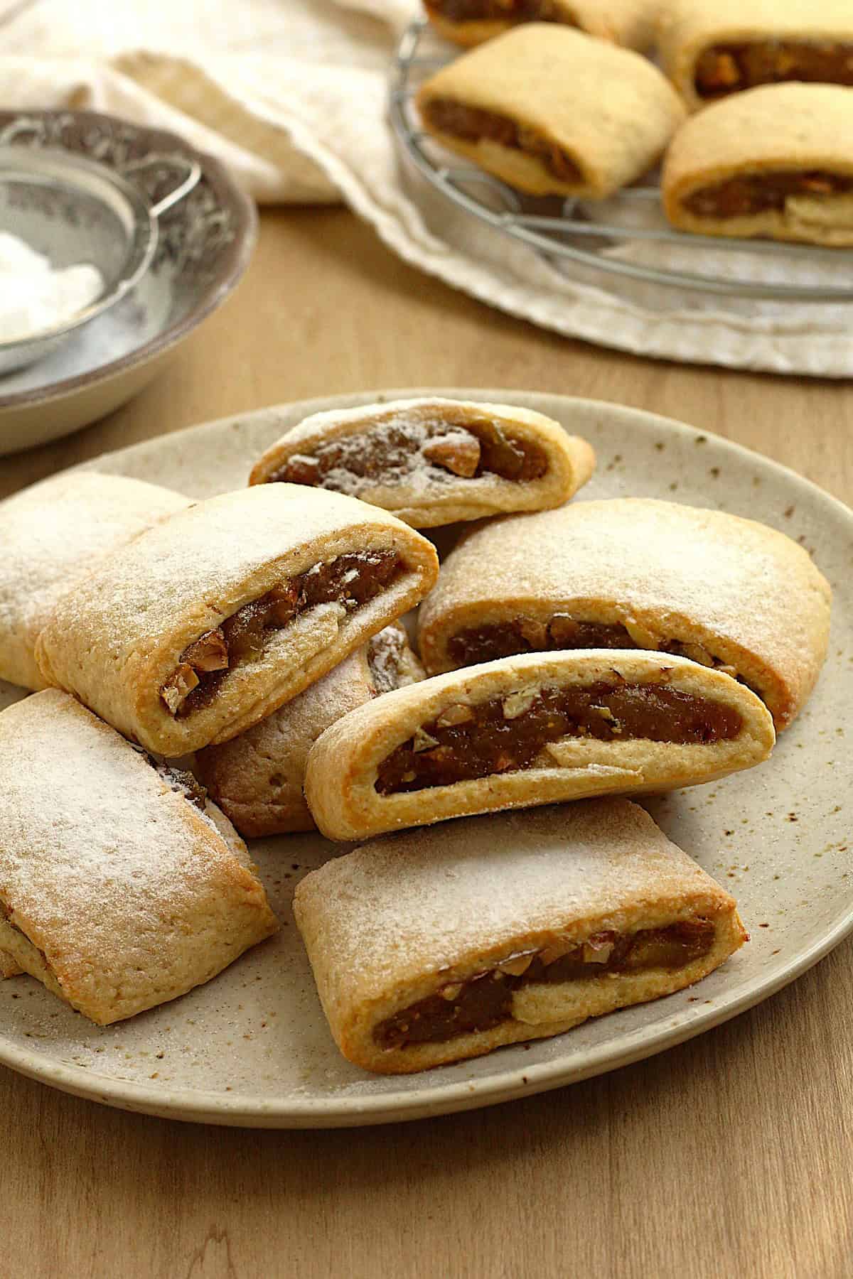 Fig jam cookies (settembrini) dusted with powdered sugar on plate.