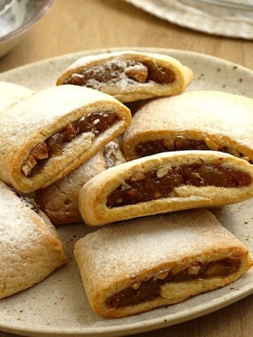 Fig cookies dusted with powdered sugar on plate.