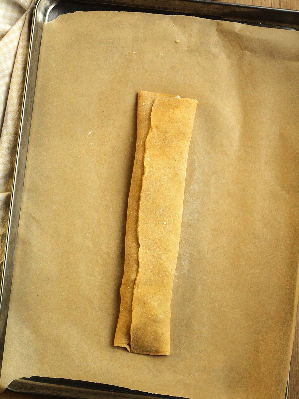 Fig jam filled shortbread dough cookie dough on baking sheet.