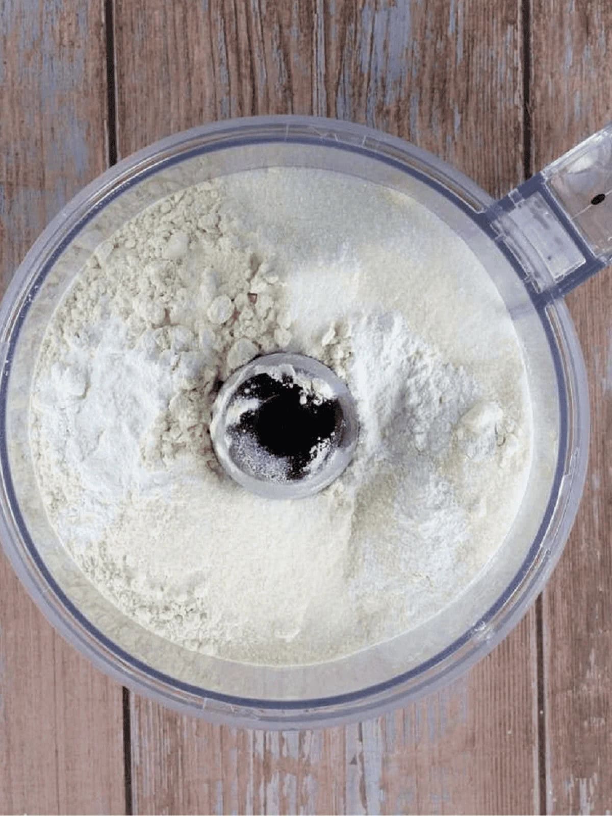 Flour, sugar and baking powder in food processor bowl for pasta frolla dough.