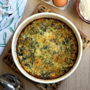 Swiss chard and ricotta bake with eggs and cheese in casserole dish topped with crips breadcrumbs.