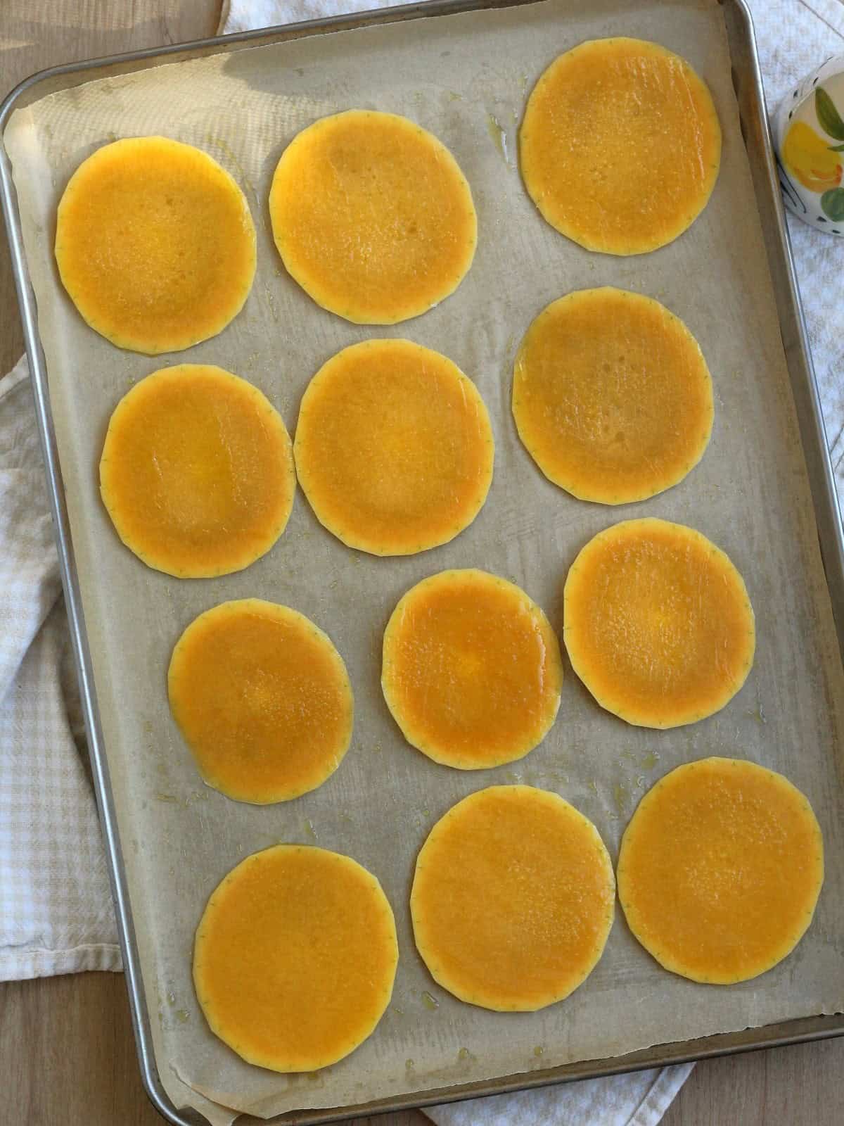 Butternut squash rounds on baking sheet brushed with olive oil.