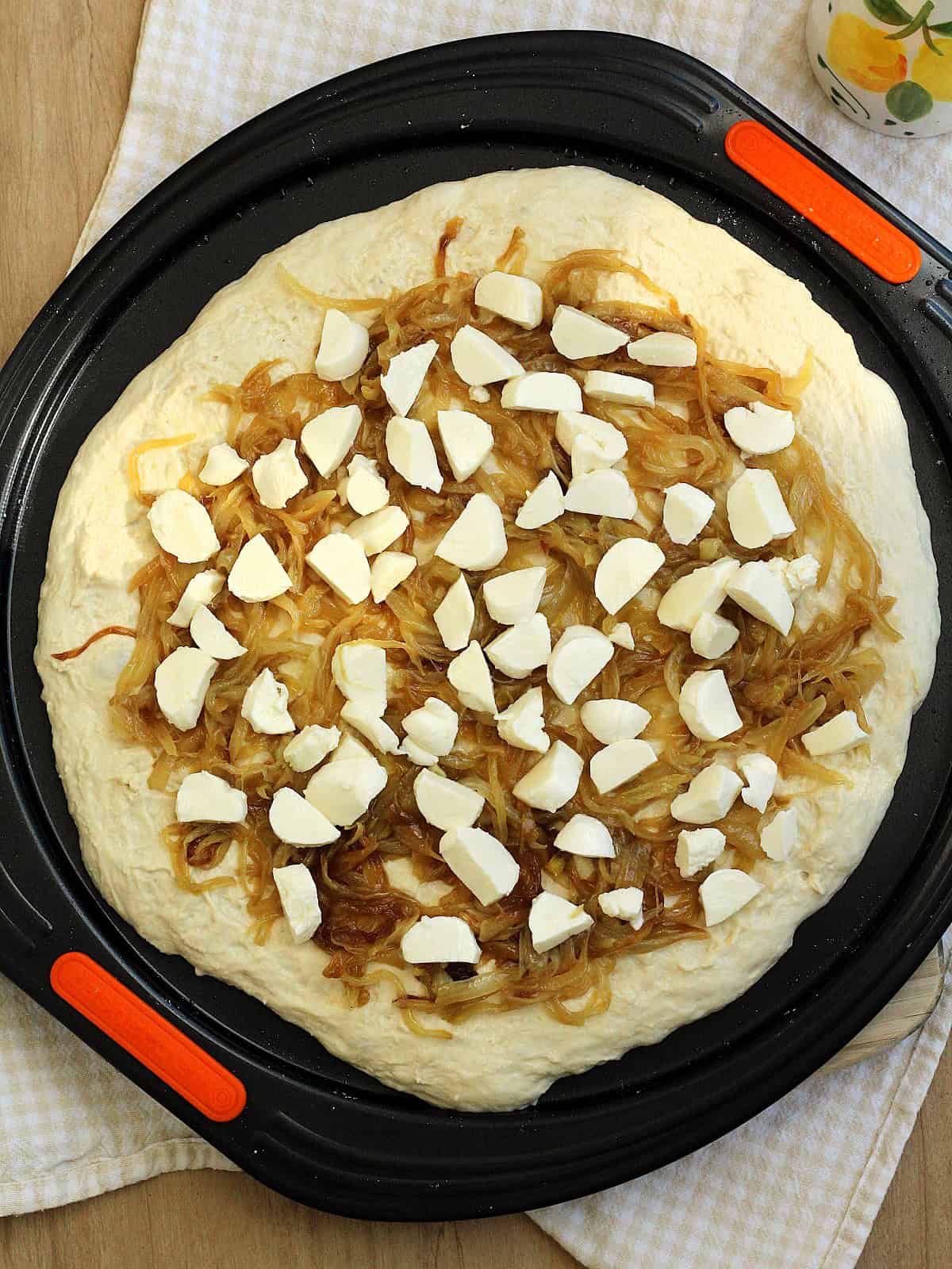 Pizza dough topped with caramelized onions and mozzarella.