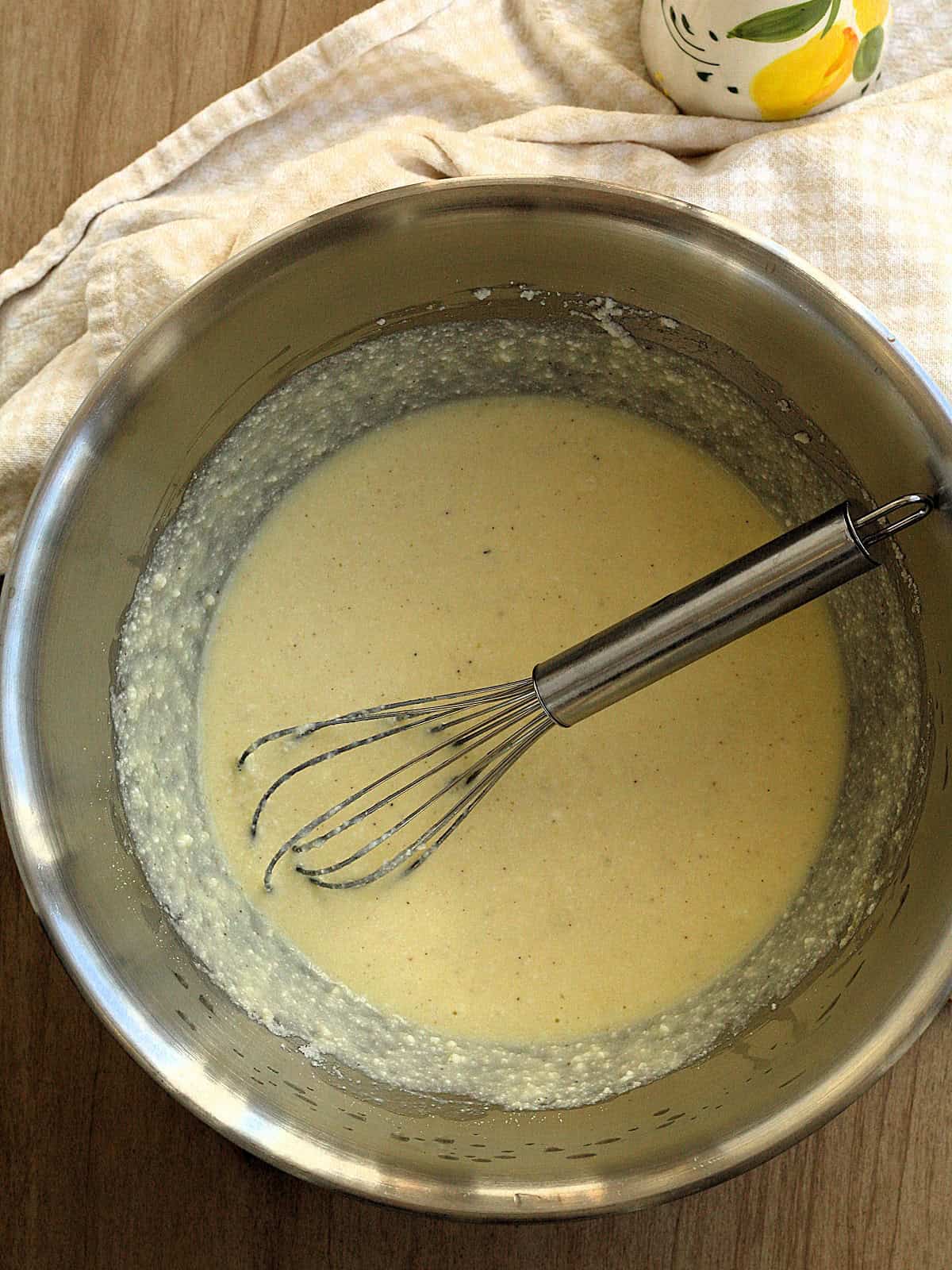 Ricotta, eggs and grated parmigiano cheese whisked in bowl.