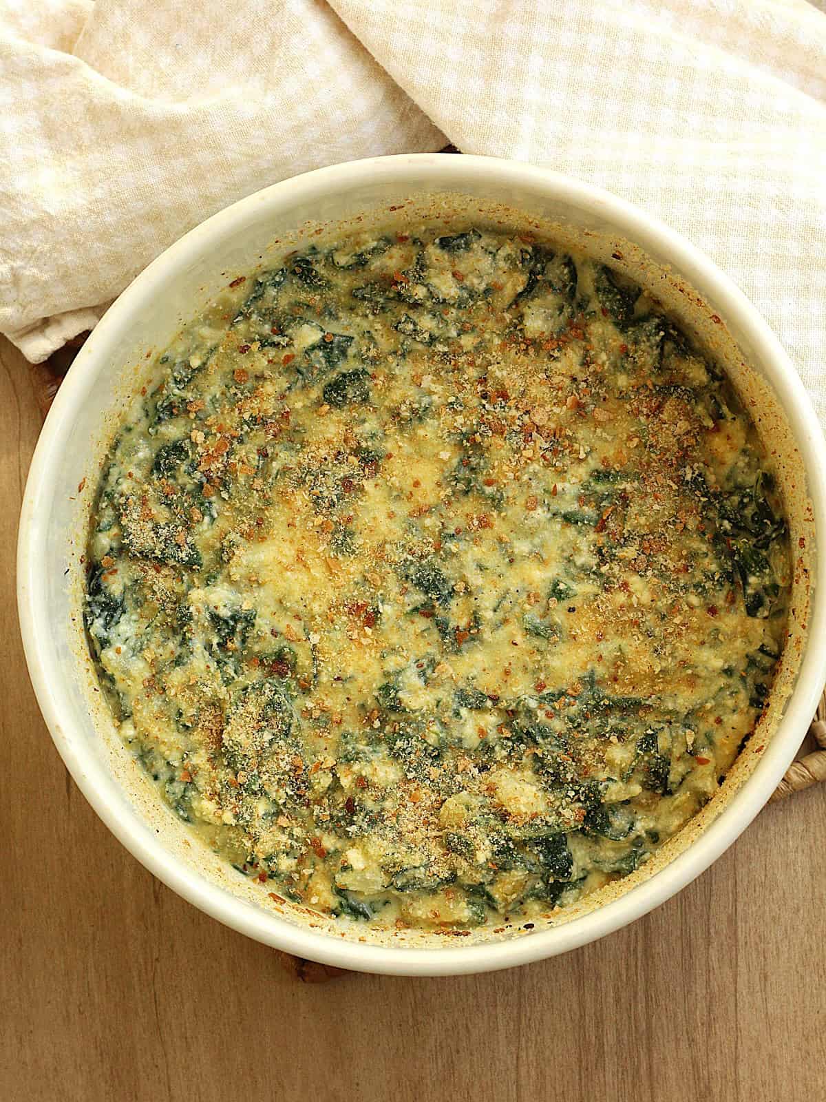 Swiss chard, ricotta and egg bake in casserole dish topped with breadcrumbs.